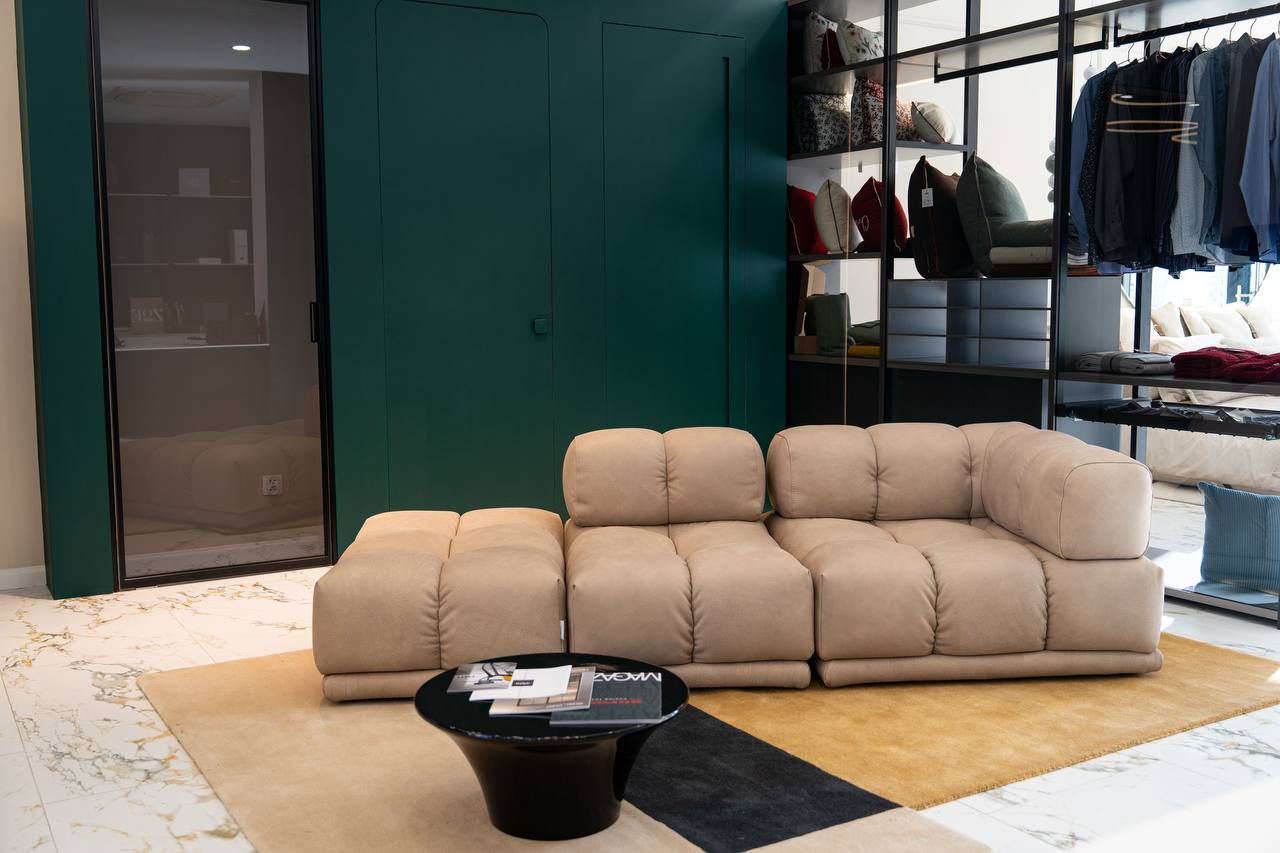 Salon z modułową sofą Sacai w obłych kształtach na tle zielonej ściany – ekspozycja w showroomie Bellissimo Home, ul. ks. Witolda 34a, Wrocław.